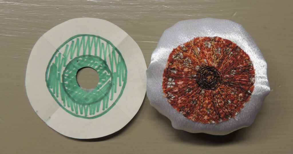After gathering and stuffing, an eyeball is compared to the template for size.