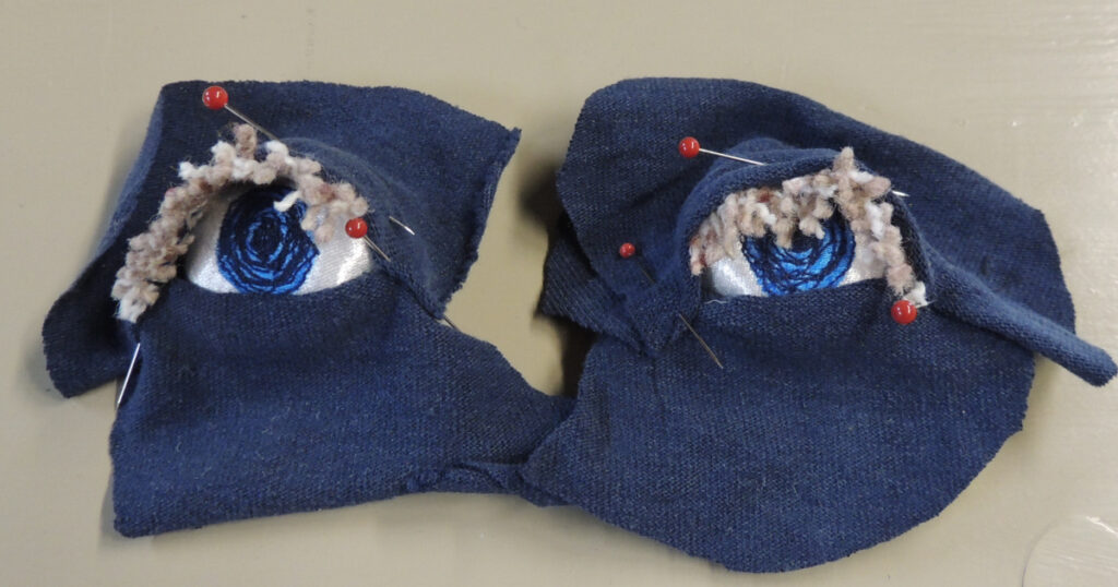 Two eyeballs with eyelids pinned and ready to sew.