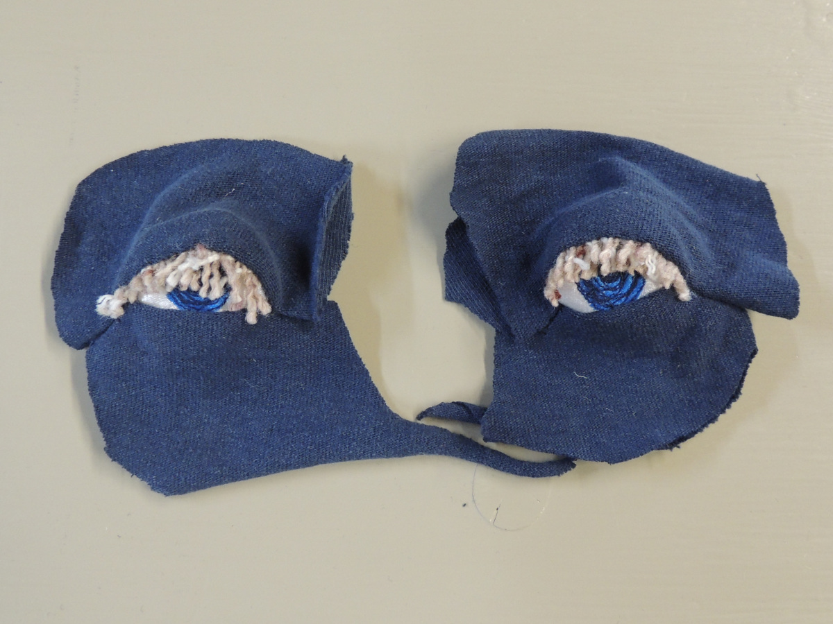 Fabric eyes with eyelids and lashes added for a realistic effect. The eyes are ready to be attached to something.