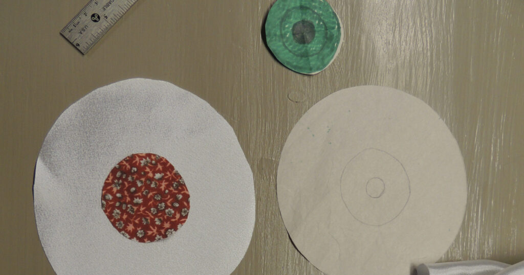 The scrap fabric for the iris is laid out in position on the eyeball fabric, ready for stitching. The iris pattern and eyeball pattern are shown at the side.