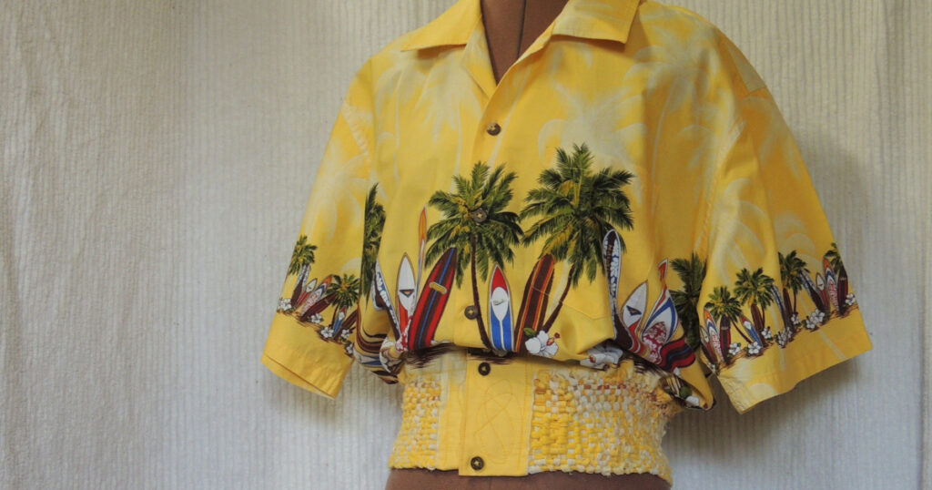 Re-woven shirt with yellow background, palm trees, and bright surfboards.  Made from a man's shirt and t-shirt pieces.
