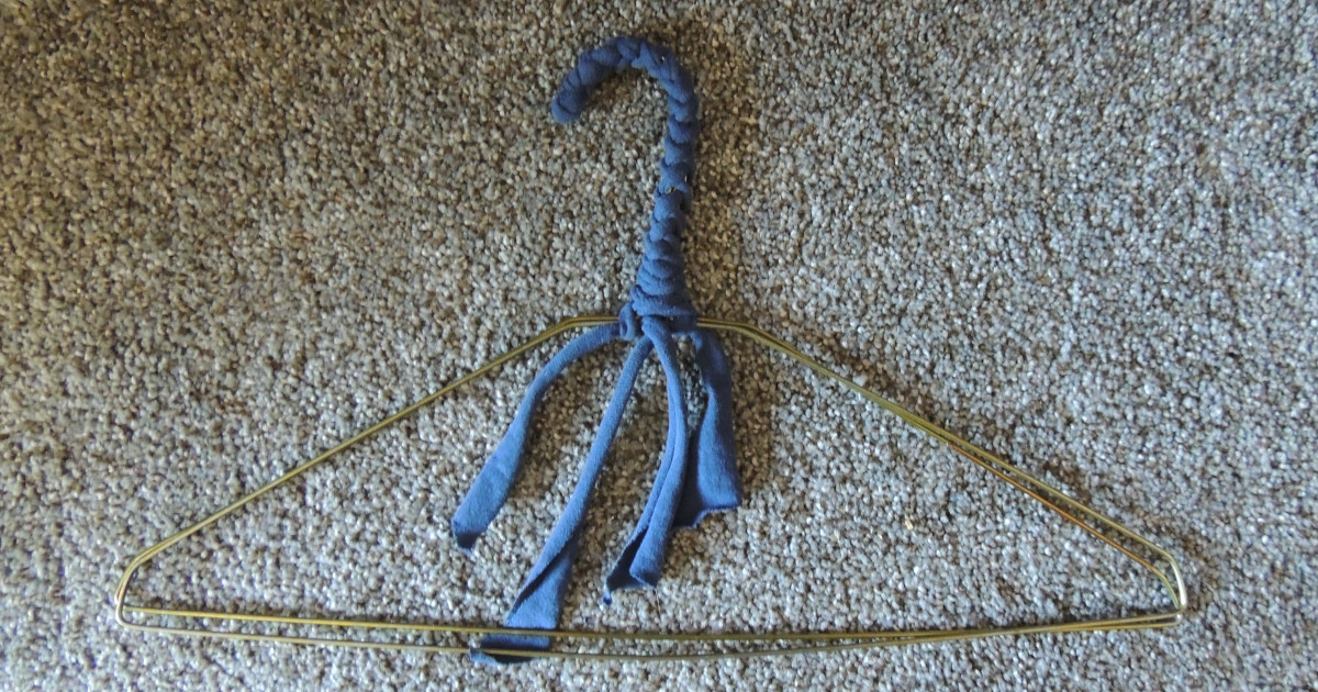 Two wire hangers with their hooks covered (together) in solid blue t-shirt yarn.